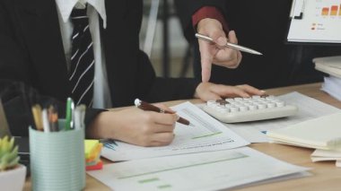 Genç Asyalı iş adamı bilgisayarda ve grafikte çalışıyor..