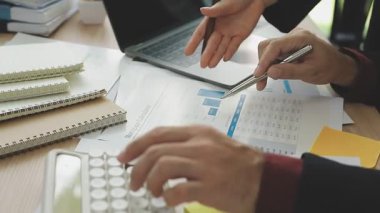 Ofiste hesap makinesi ve dizüstü bilgisayarla çalışan iş adamı