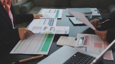 Modern ofiste finansal belgeler üzerinde çalışan iş adamları