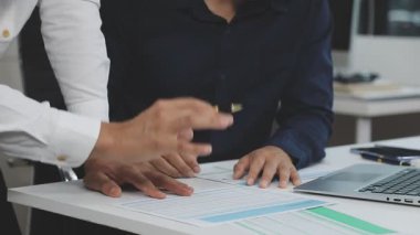 İş yerinde dizüstü bilgisayarı ve kalemi olan Asyalı genç bir iş adamı..