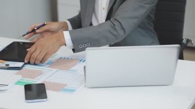 Modern ofiste çalışan iş adamı, dizüstü bilgisayarı ve akıllı telefonu var.