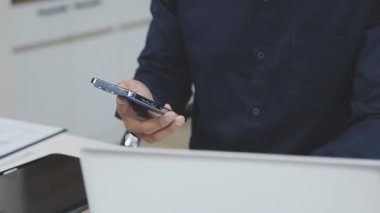 İş adamı cep telefonu kullanıyor ve online alışveriş için kredi kartı tutuyor..