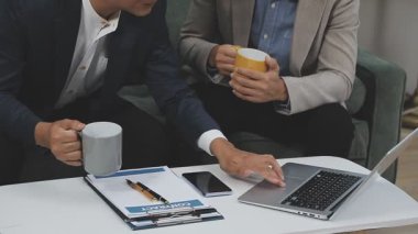 Ofiste bir fincan kahve ve dizüstü bilgisayarı olan bir iş adamı.