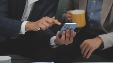 İş adamı ofisinde kahve fincanı ve akıllı telefon kullanıyor. İş konsepti..