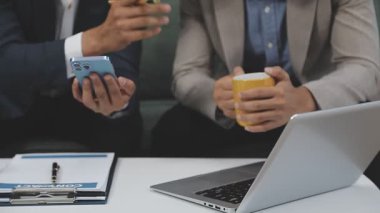 Ofiste akıllı telefonu ve bilgisayarı olan bir iş adamı.