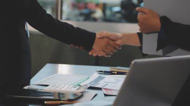 İş adamları ofiste el sıkışıyor, iş toplantısı yapıyorlar.
