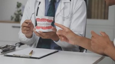 Doktor diş tedavisi gösteriyor.