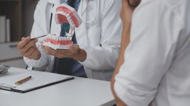 dişçi dişlerini gösteriyor ve nasıl hasta olacağını anlatıyor.