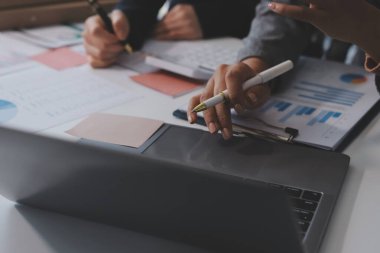 Muhasebe şirketi kazançlı nakit akışı için finansman ve vergilendirme planlaması, ofiste çalışan denetçi ve muhasebeci ekibi, mali verileri ve muhasebe kayıtlarını hesap makinesiyle analiz eder.