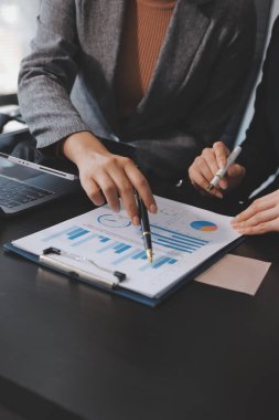 Muhasebe şirketi kazançlı nakit akışı için finansman ve vergilendirme planlaması, ofiste çalışan denetçi ve muhasebeci ekibi, mali verileri ve muhasebe kayıtlarını hesap makinesiyle analiz eder.