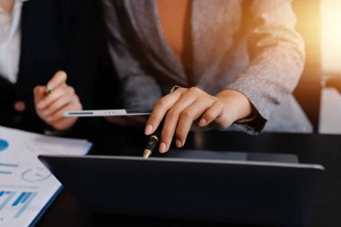 Muhasebe şirketi kazançlı nakit akışı için finansman ve vergilendirme planlaması, ofiste çalışan denetçi ve muhasebeci ekibi, mali verileri ve muhasebe kayıtlarını hesap makinesiyle analiz eder.