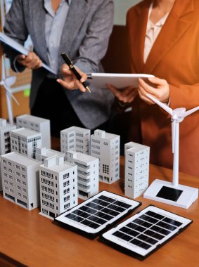 İş adamları arasında güneş pili paneli teknolojisi ve Güneş Enerjisi Çevre Kenti kavramındaki son gelişmeler üzerine tartışma.