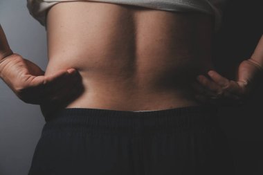 Asyalı şişman bir adam aynanın önünde vücuduna bakıyor. Aşırı göbek yağı, sağlıksız yaşam tarzı, diyet konsepti.