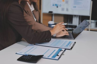 Muhasebe şirketi kazançlı nakit akışı için finansman ve vergilendirme planlaması, ofiste çalışan denetçi ve muhasebeci ekibi, mali verileri ve muhasebe kayıtlarını hesap makinesiyle analiz eder.