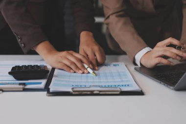 Muhasebe şirketi kazançlı nakit akışı için finansman ve vergilendirme planlaması, ofiste çalışan denetçi ve muhasebeci ekibi, mali verileri ve muhasebe kayıtlarını hesap makinesiyle analiz eder.