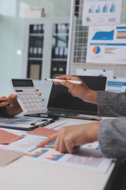 Muhasebe şirketi kazançlı nakit akışı için finansman ve vergilendirme planlaması, ofiste çalışan denetçi ve muhasebeci ekibi, mali verileri ve muhasebe kayıtlarını hesap makinesiyle analiz eder.