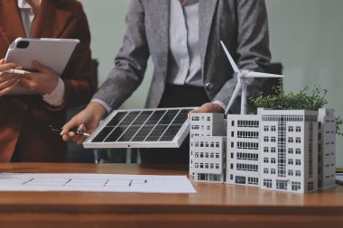 İş adamları arasında güneş pili paneli teknolojisi ve Güneş Enerjisi Çevre Kenti kavramındaki son gelişmeler üzerine tartışma.