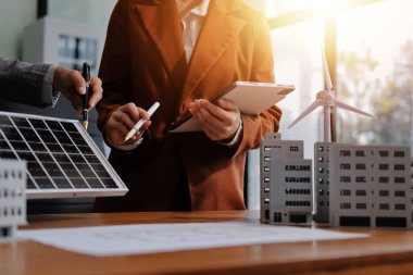İş adamları arasında güneş pili paneli teknolojisi ve Güneş Enerjisi Çevre Kenti kavramındaki son gelişmeler üzerine tartışma.