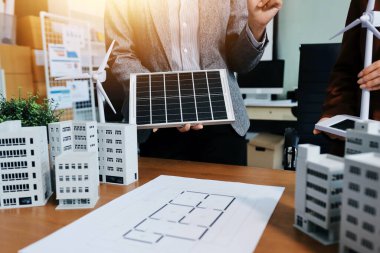 İş adamları arasında güneş pili paneli teknolojisi ve Güneş Enerjisi Çevre Kenti kavramındaki son gelişmeler üzerine tartışma.