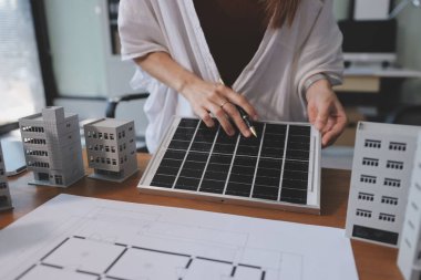 İş adamları arasında güneş pili paneli teknolojisi ve Güneş Enerjisi Çevre Kenti kavramındaki son gelişmeler üzerine tartışma.