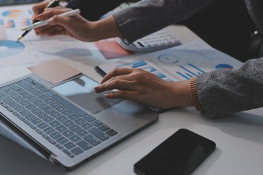 Muhasebe şirketi kazançlı nakit akışı için finansman ve vergilendirme planlaması, ofiste çalışan denetçi ve muhasebeci ekibi, mali verileri ve muhasebe kayıtlarını hesap makinesiyle analiz eder.