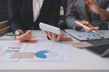 Muhasebe şirketi kazançlı nakit akışı için finansman ve vergilendirme planlaması, ofiste çalışan denetçi ve muhasebeci ekibi, mali verileri ve muhasebe kayıtlarını hesap makinesiyle analiz eder.
