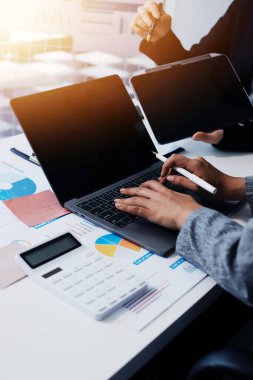 Muhasebe şirketi kazançlı nakit akışı için finansman ve vergilendirme planlaması, ofiste çalışan denetçi ve muhasebeci ekibi, mali verileri ve muhasebe kayıtlarını hesap makinesiyle analiz eder.