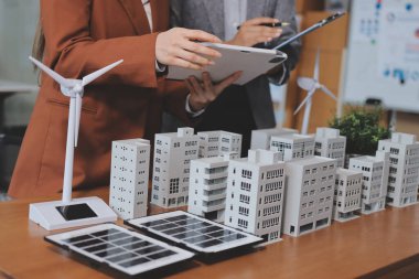 İş adamları arasında güneş pili paneli teknolojisi ve Güneş Enerjisi Çevre Kenti kavramındaki son gelişmeler üzerine tartışma.