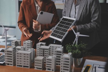 İş adamları arasında güneş pili paneli teknolojisi ve Güneş Enerjisi Çevre Kenti kavramındaki son gelişmeler üzerine tartışma.