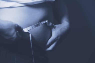 Asyalı şişman bir adam aynanın önünde vücuduna bakıyor. Aşırı göbek yağı, sağlıksız yaşam tarzı, diyet konsepti.