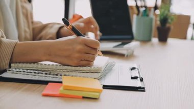 Genç bayan tasarımcı bir deftere çizim yapıyor.