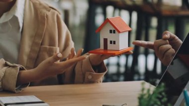 İş adamları bilgisayarda çalışıyor ve evdeki müşteriyi bulmak için akıllı telefon kullanıyorlar..