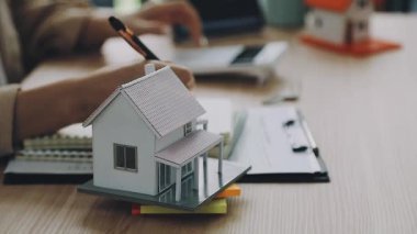 Hesap makinesi ve kalemi olan minyatür bir ev..