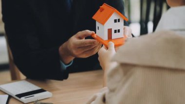 Kiralık ya da acente için ev modeli veren iki emlakçı..