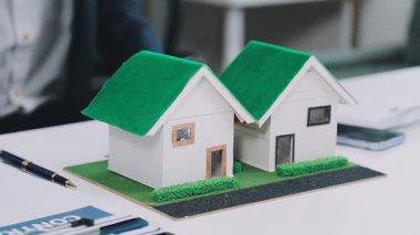 Masasında ev modeli olan minyatür bir ev.