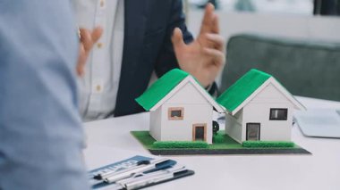 Erkek ve kadın ev modeli tutuyorlar.