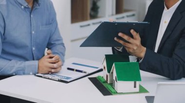 Ofisinde emlakçı olan iş adamı model ev modelini tutuyor. mortgage kredisi ve kredi kavramı