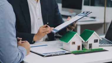 Emlakçı ev modelini gösteriyor.