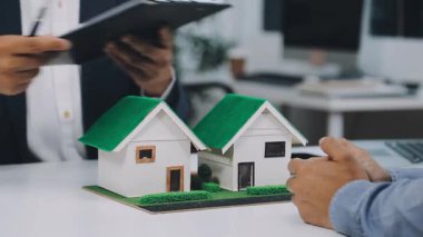 İş adamları ev modeli, emlakçı ya da temsilci tutuyorlar, ev, sigorta acentesi, sözleşme ya da ev satın almak için sözleşme imzalıyorlar.