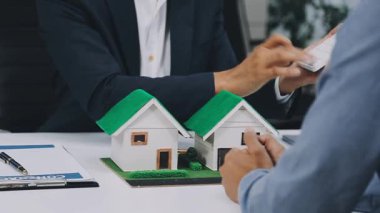 Takım elbiseli adam evin anahtarını tutuyor.