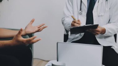 Ofisteki masada steteskoplu genç bir doktor oturuyor.