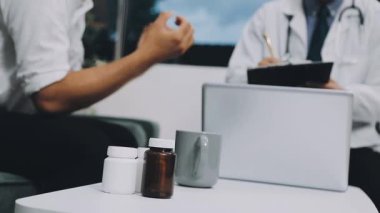 Beyaz önlüklü doktor elinde bir kutu hap tutuyor.