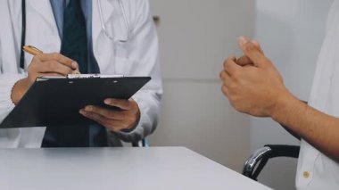 Doktor ve hasta tartışıyorlar ve notlar yazıyorlar