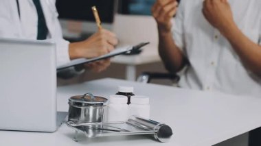 Beyaz önlüklü erkek doktor ve siyah üniformalı hasta ile hastane, sağlık ve tıp konsepti hakkında konuşuyor.