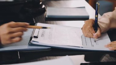 İş yerindeki belgeye yazan iş kadınını kapatın. Modern ofiste çalışan iş adamları