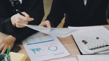 İş adamı hesap makinesi ve kalemle finansal tabloları analiz ediyor.