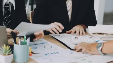 Ekonomik rapor ve hesap makinesiyle çalışan iş ekibi.