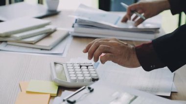 Ofiste hesap makinesi olan bir işadamı.