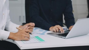 Modern ofiste dizüstü bilgisayarla ve finansal belgelerle çalışan genç işletme ekibini kapatın..