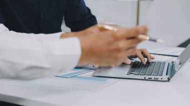 Ofisteki masada dizüstü bilgisayar kullanarak iş adamının elini kapat..